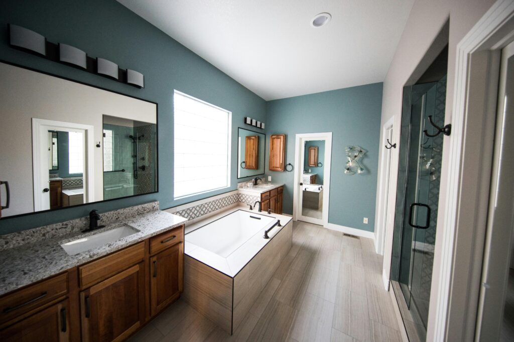 pexels photo 1909791 1909791 Spacious modern bathroom featuring a freestanding bathtub, wooden cabinets, and granite countertops.
