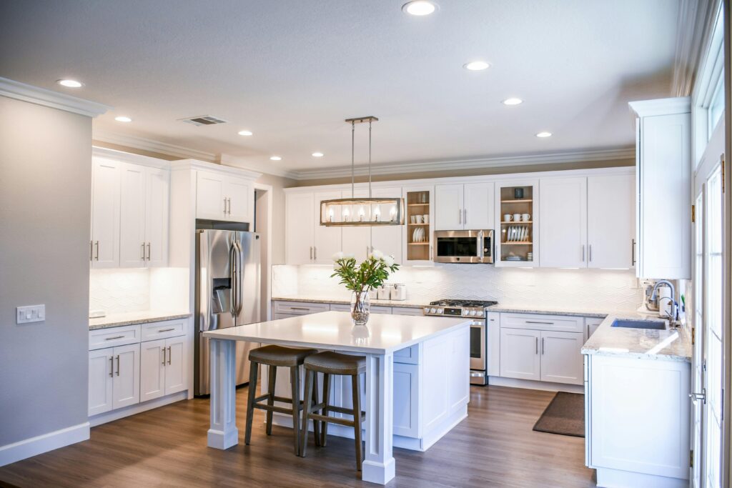 pexels photo 2724748 2724748 Elegant white kitchen featuring an island, modern appliances, and ample natural light.
