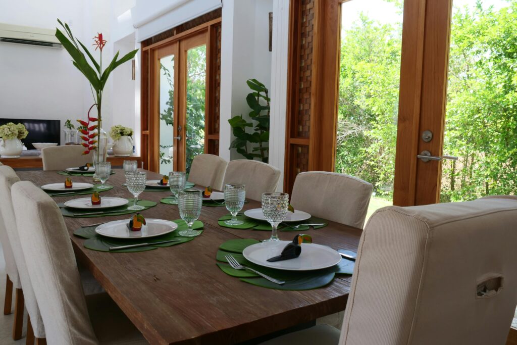pexels photo 7900468 7900468 Beautifully arranged dining table with toucan themed setting and leafy centerpiece.